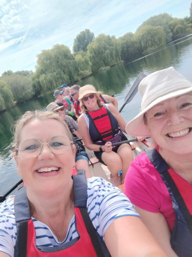 Paddlers are in the dragonboat smiling at the camera.